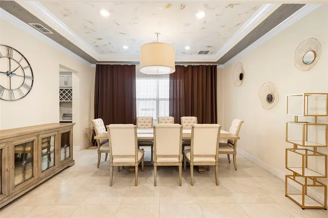 a kitchen with stainless steel appliances a stove a table chairs and a chandelier