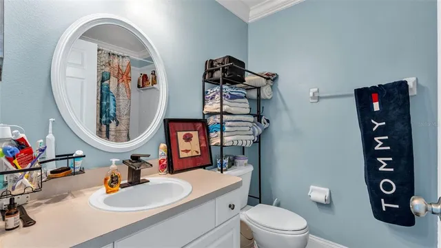 a bathroom with a toilet sink mirror and vanity