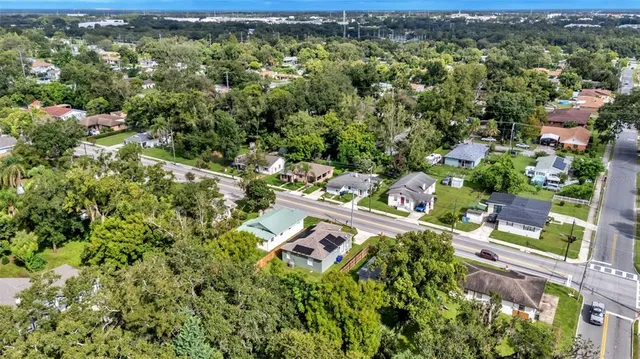 an aerial view of residential houses with outdoor space and trees