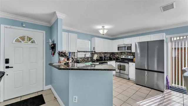 a kitchen with kitchen island a counter top space cabinets and stainless steel appliances
