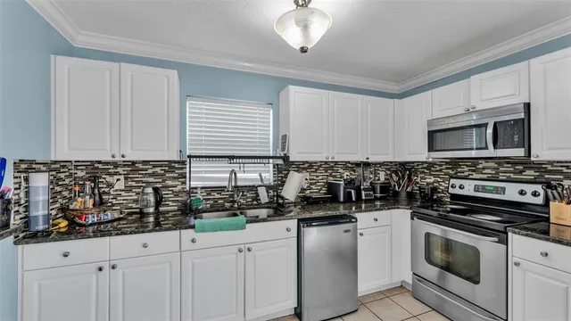 a kitchen with stainless steel appliances a stove a sink a microwave and cabinets