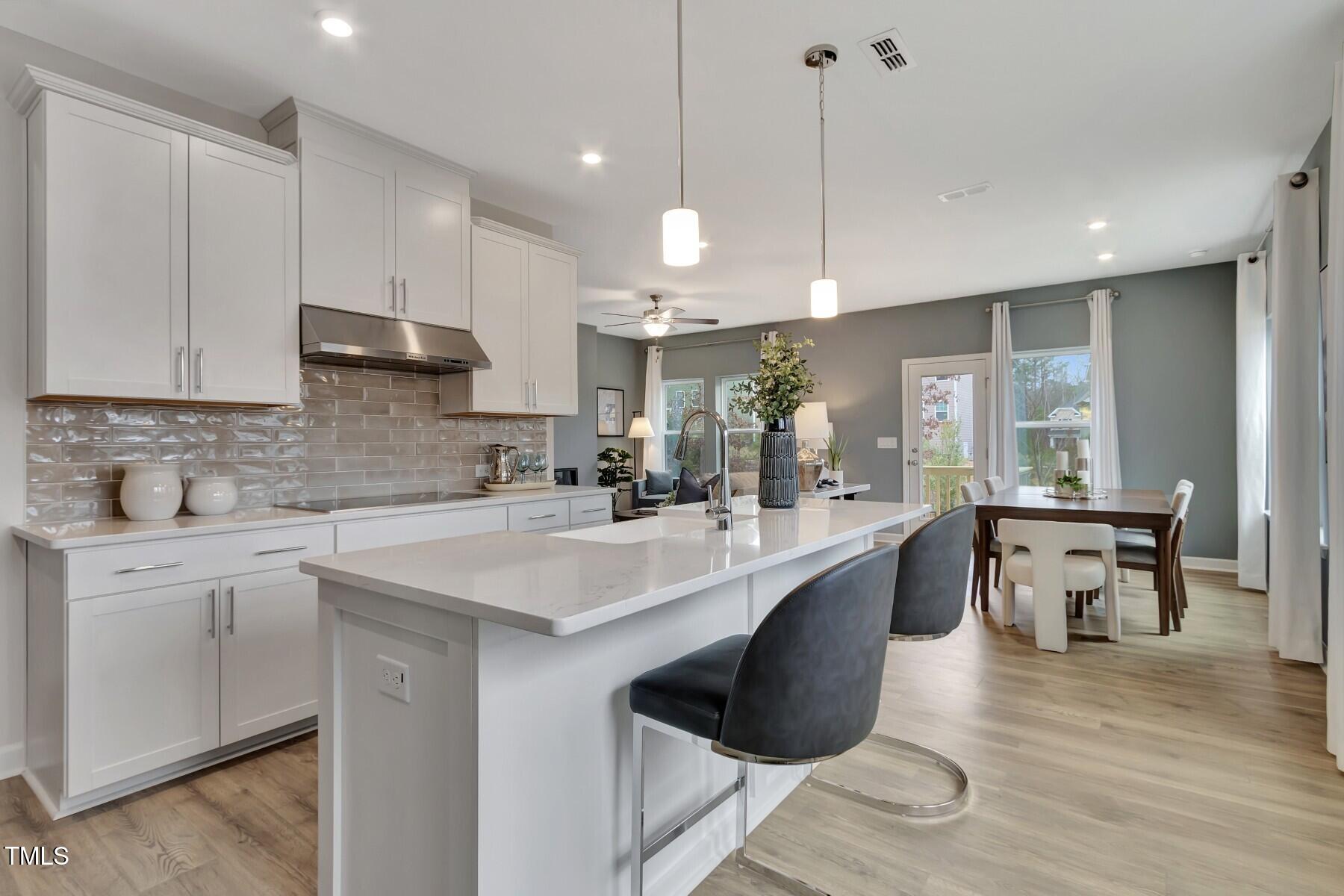 7128 Hubner Place, Unit 35 Cary, NC 27519 - Photo 7 of 17 a large kitchen with kitchen island a sink a stove a center island and furniture