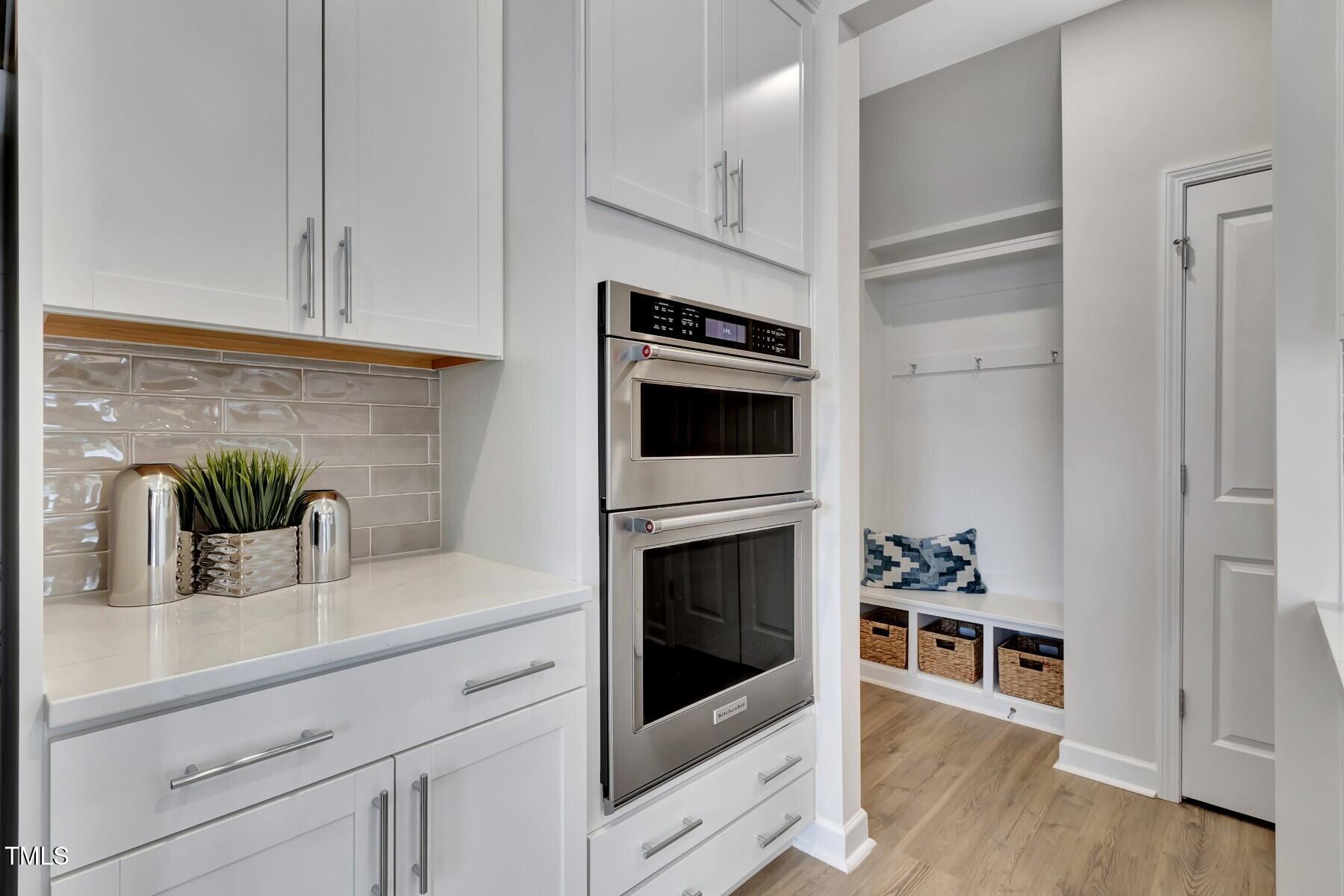 7128 Hubner Place, Unit 35 Cary, NC 27519 - Photo 8 of 17 a kitchen with stainless steel appliances white cabinets and a wooden floor