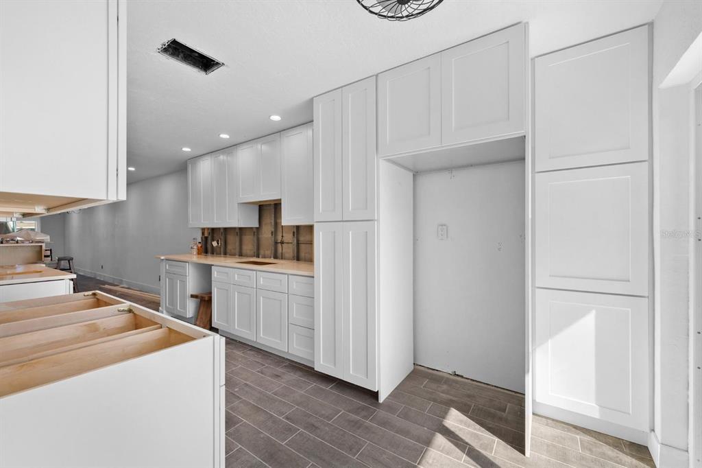 511 Boca Ciega Point Boulevard North St. Petersburg, FL 33708 - Photo 15 of 24 a kitchen with white cabinets and stainless steel appliances