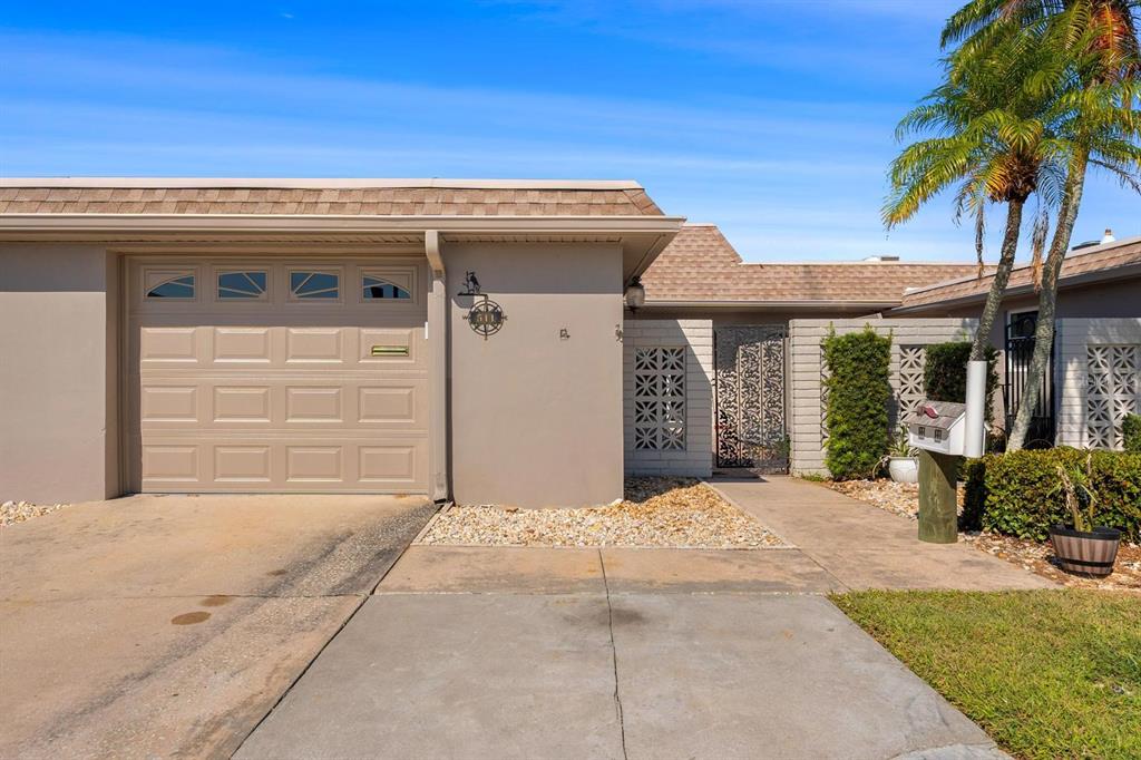 511 Boca Ciega Point Boulevard North St. Petersburg, FL 33708 - Photo 21 of 24 a front view of a house with a garden and entryway