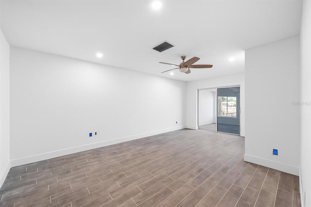 511 Boca Ciega Point Boulevard North St. Petersburg, FL 33708 - Photo 6 of 24 a view of a room with wooden floor and ceiling fan