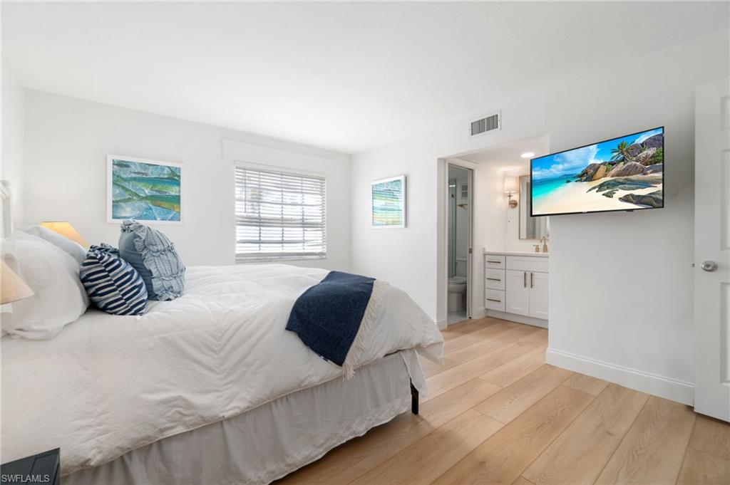 1222 Gordon Drive, Unit 2 Naples, FL 34102 - Photo 12 of 23 a bedroom with a bed and a flat screen tv