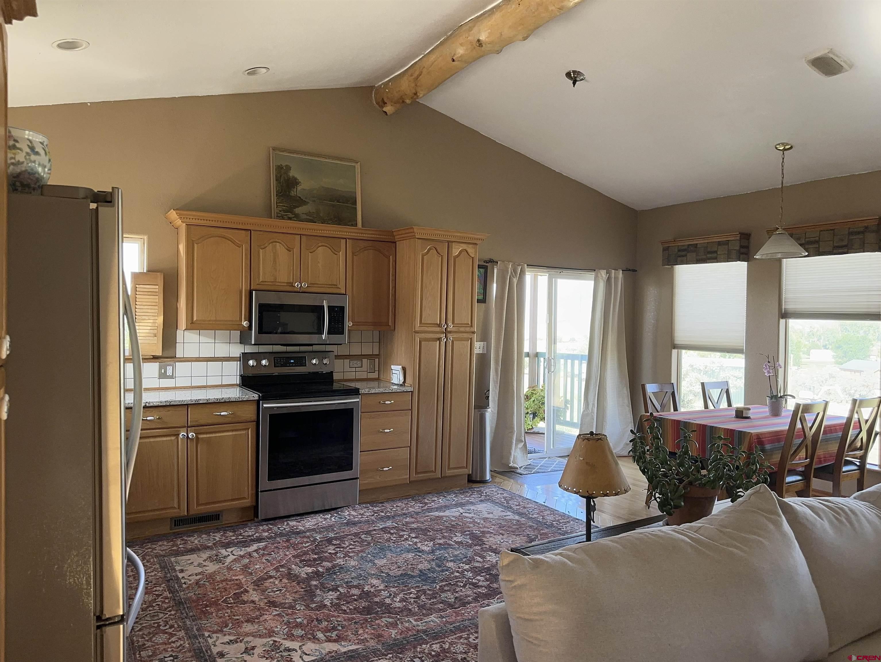 16432 Bull Mesa Road Cedaredge, CO 81413 - Photo 4 of 15 a living room with furniture a large window and a fireplace