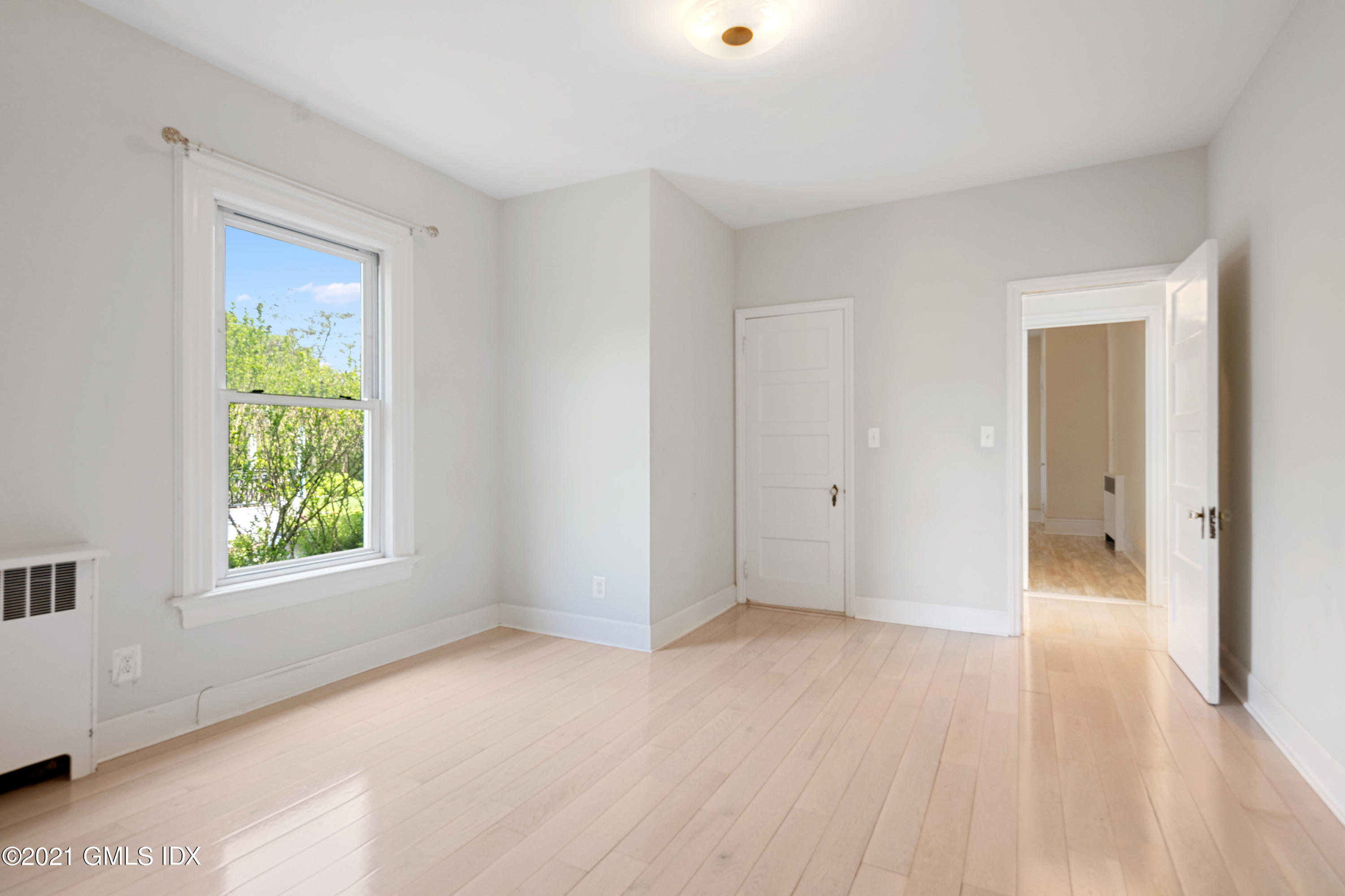 14 Byram Shore Road, Unit 1 Greenwich, CT 06830 - Photo 13 of 30 a view of an empty room with wooden floor and a window