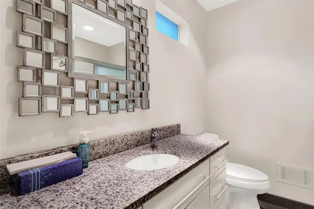 a bathroom with a granite countertop sink and a mirror
