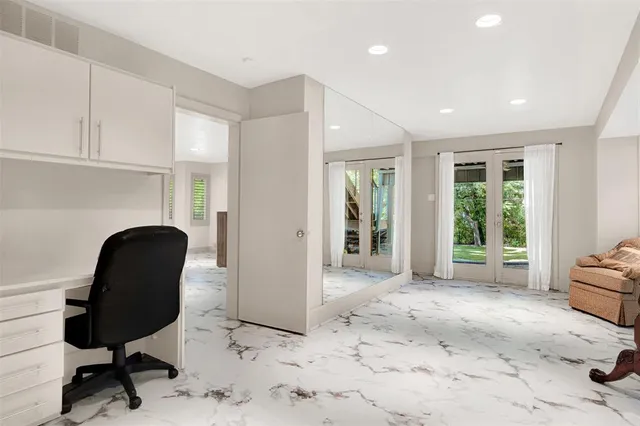 a view of a workspace with furniture and a window