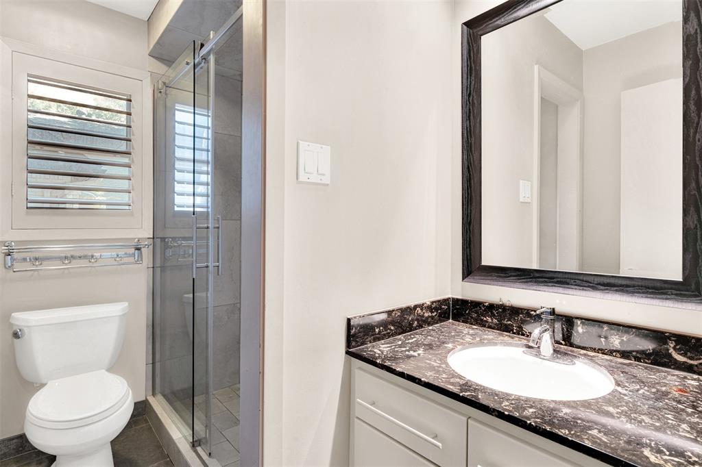 13311 Purple Sage Road Dallas, TX 75240 - Photo 24 of 26 a bathroom with a granite countertop sink toilet and mirror