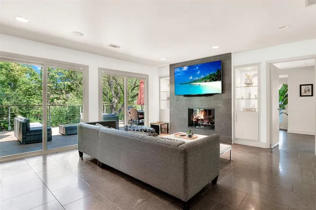 a living room with furniture a large window and a flat screen tv