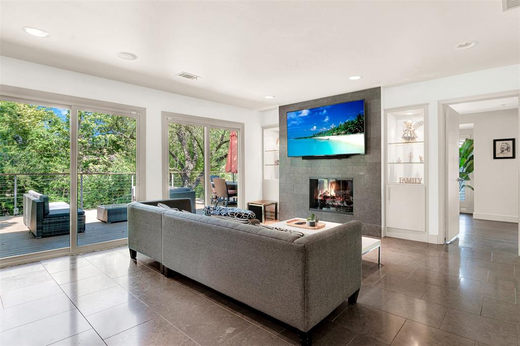 13311 Purple Sage Road Dallas, TX 75240 - Photo 4 of 26 a living room with furniture a large window and a flat screen tv