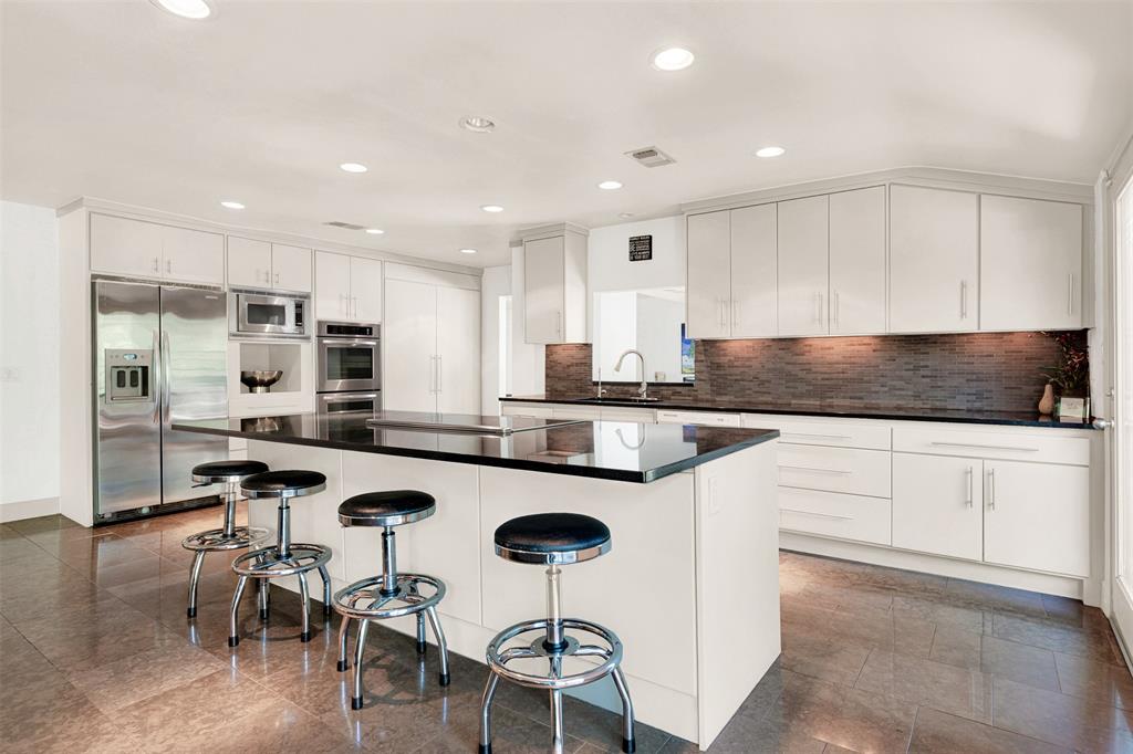 13311 Purple Sage Road Dallas, TX 75240 - Photo 7 of 26 a kitchen with stainless steel appliances granite countertop a stove a sink a refrigerator and white cabinets with wooden floor