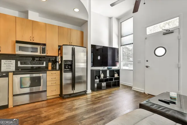 a kitchen with granite countertop a refrigerator and a stove top oven