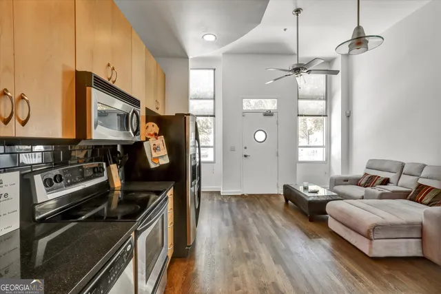 a large kitchen with stainless steel appliances a stove a refrigerator and a fireplace