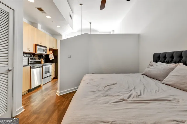 a bedroom with a bed and a view of kitchen