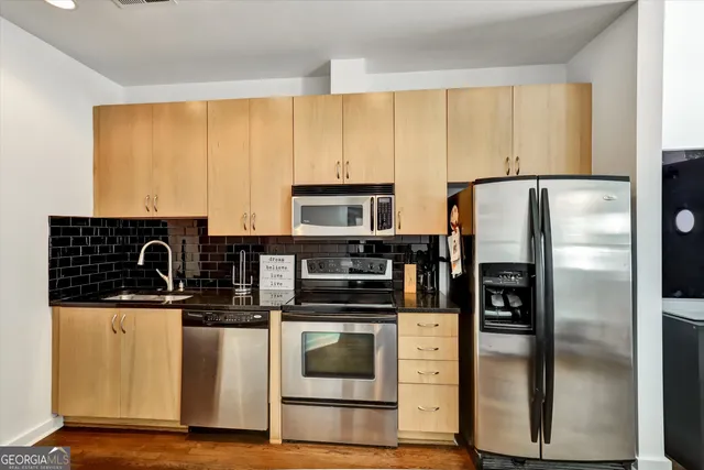 a kitchen with stainless steel appliances a refrigerator stove and sink
