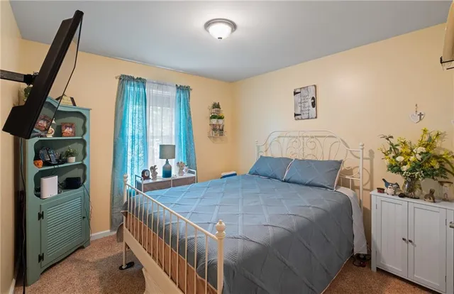 a bedroom with a bed and a flat tv screen on dresser