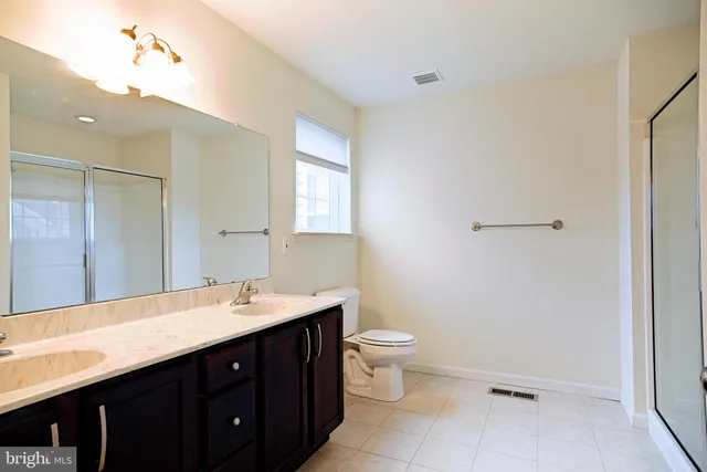 a bathroom with a double vanity sink toilet and a mirror