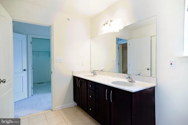 a bathroom with a double vanity sink and mirror