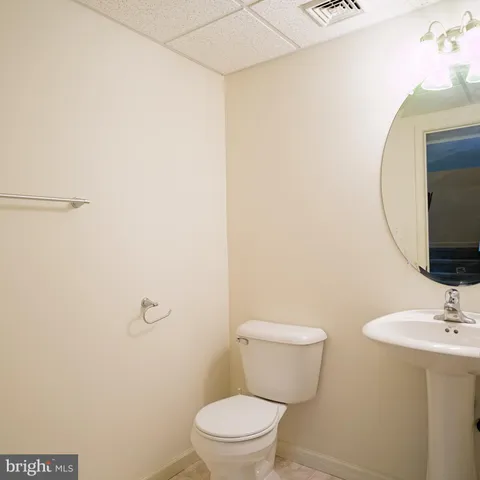 a bathroom with a toilet a sink and mirror
