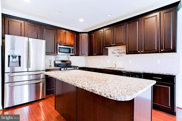 a kitchen with granite countertop stainless steel appliances and wooden cabinets