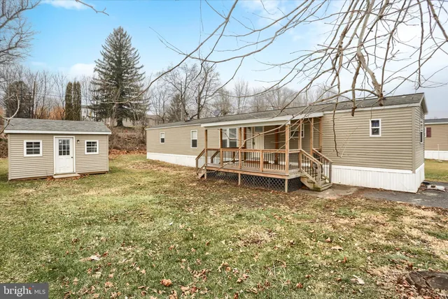 a white house that has a small yard and a large tree