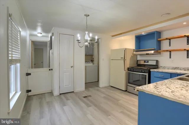 a kitchen with stainless steel appliances granite countertop a refrigerator a sink dishwasher a dining table and chairs