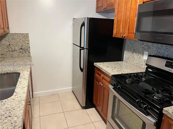 a kitchen with granite countertop a stove and a refrigerator