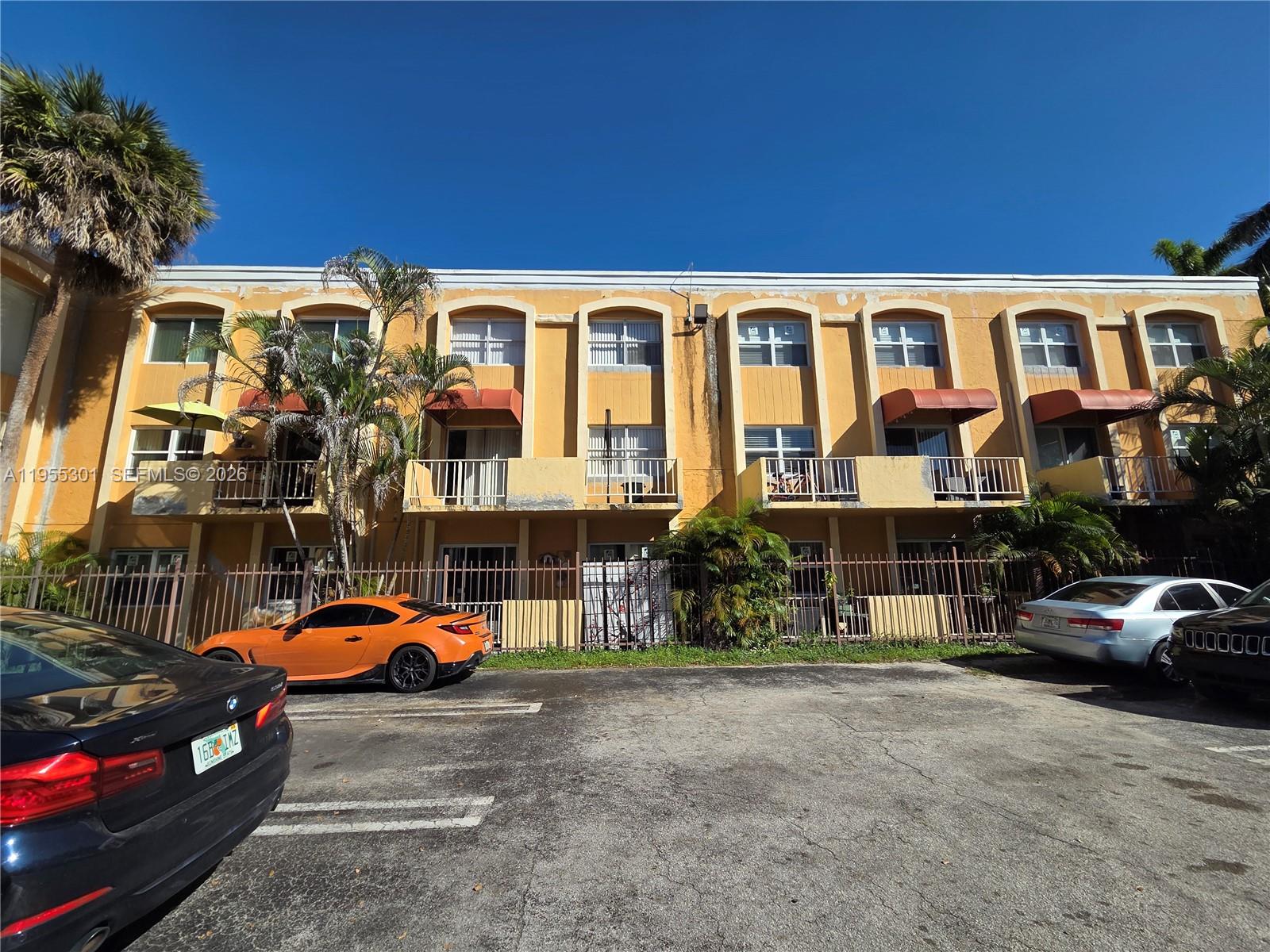 17901 Northwest 68th Avenue, Unit T106 Hialeah, FL 33015 - Photo 31 of 31 a view of a cars park in front of a building
