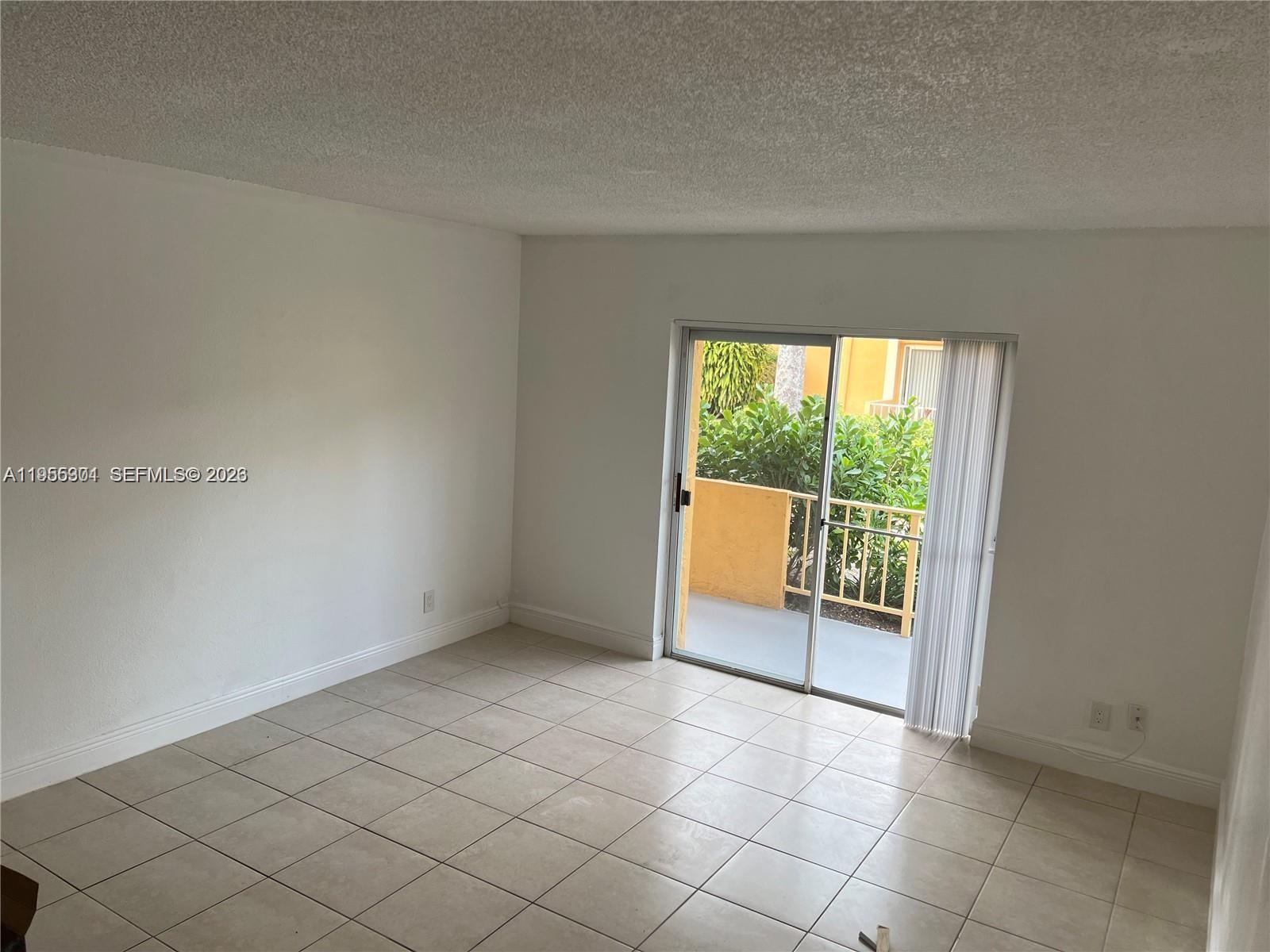 17901 Northwest 68th Avenue, Unit T106 Hialeah, FL 33015 - Photo 6 of 31 an empty room with windows