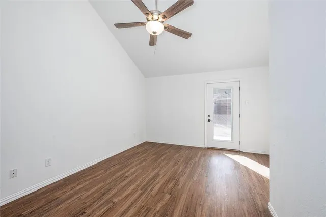 an empty room with a window and wooden floor