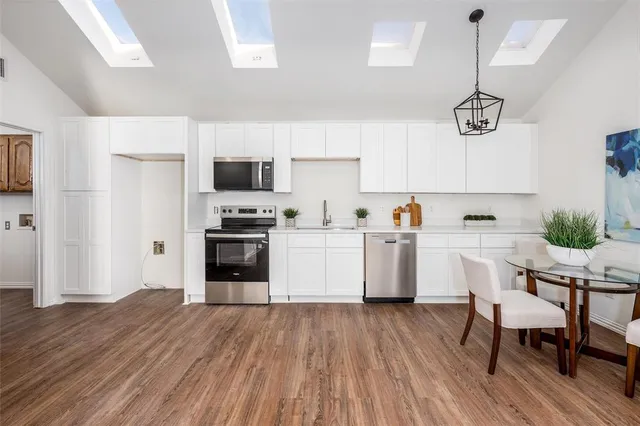 a kitchen with a sink cabinets and wooden floor