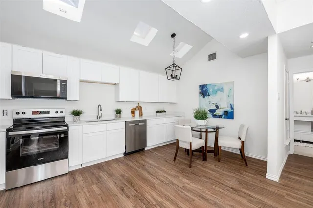 a kitchen with a dining table chairs and stainless steel appliances