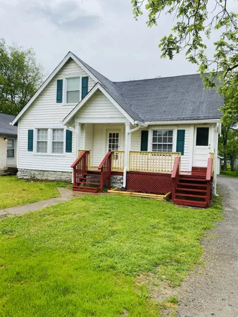a view of a house with a yard and sitting area