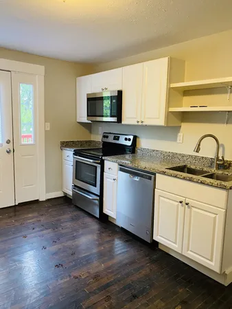 a kitchen with granite countertop wooden floors and stainless steel appliances