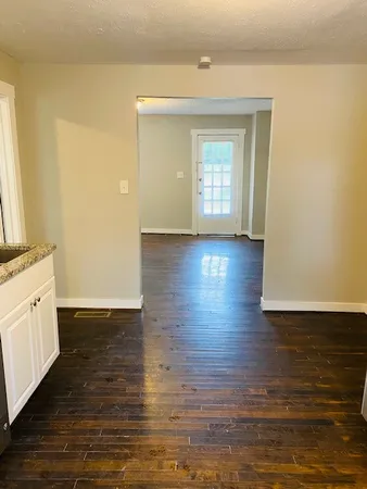 a view of a kitchen with wooden floor and a window