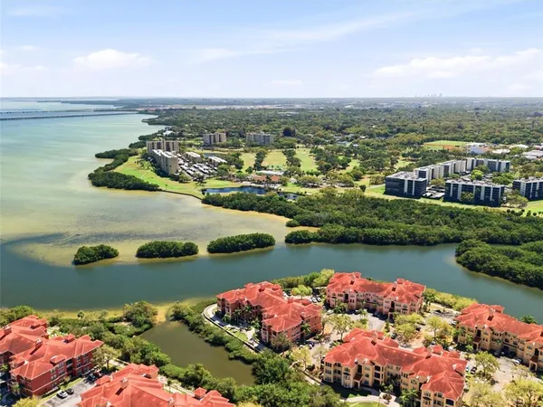 an aerial view of ocean and residential houses with outdoor space