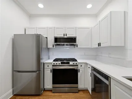a kitchen with stainless steel appliances granite countertop a sink dishwasher a stove and a microwave oven with granite countertops
