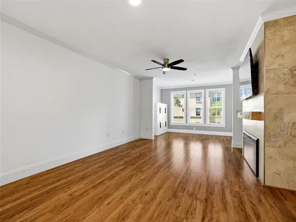 a view of empty room with wooden floor and fireplace