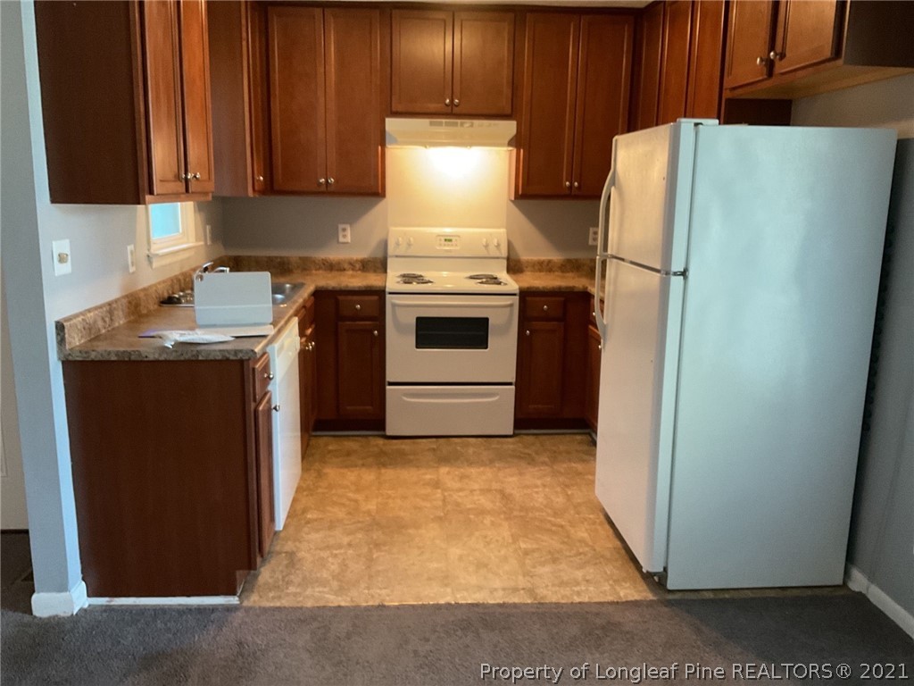 2279 Hackney Loop Fayetteville, NC 28304 - Photo 5 of 11 a kitchen with a stove top oven and refrigerator