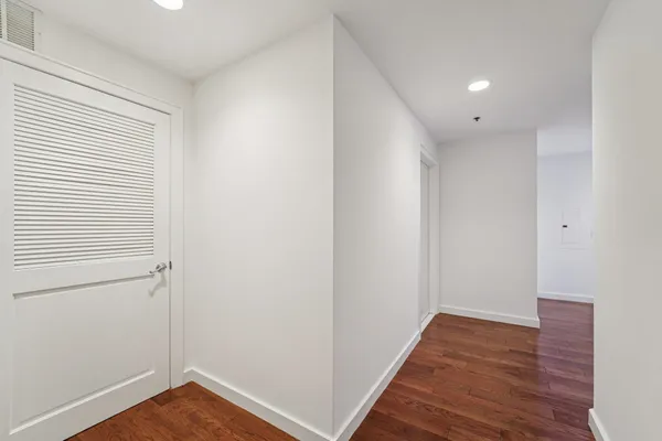 a view of a hallway with wooden floor