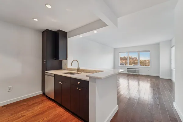 a view of a kitchen counter space a sink and wooden floor