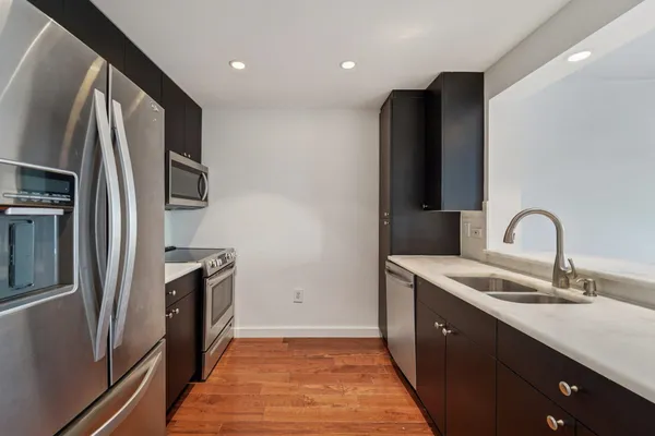 a kitchen with stainless steel appliances granite countertop a refrigerator and a sink