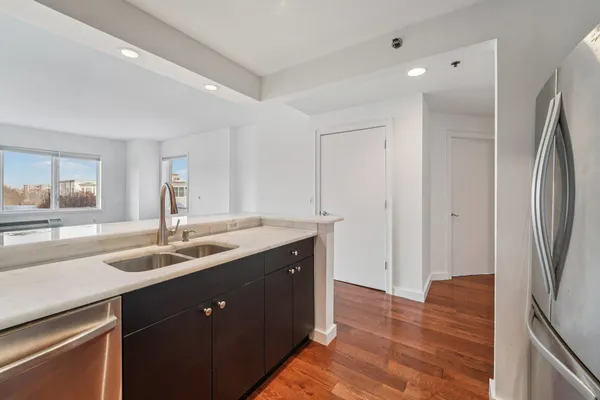 a kitchen with stainless steel appliances granite countertop a sink and a refrigerator
