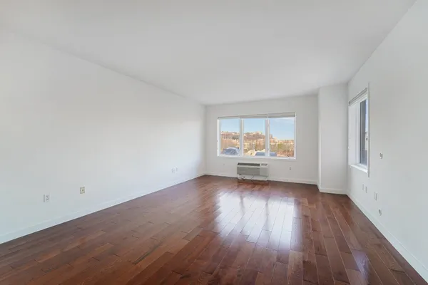 wooden floor in an empty room with a window