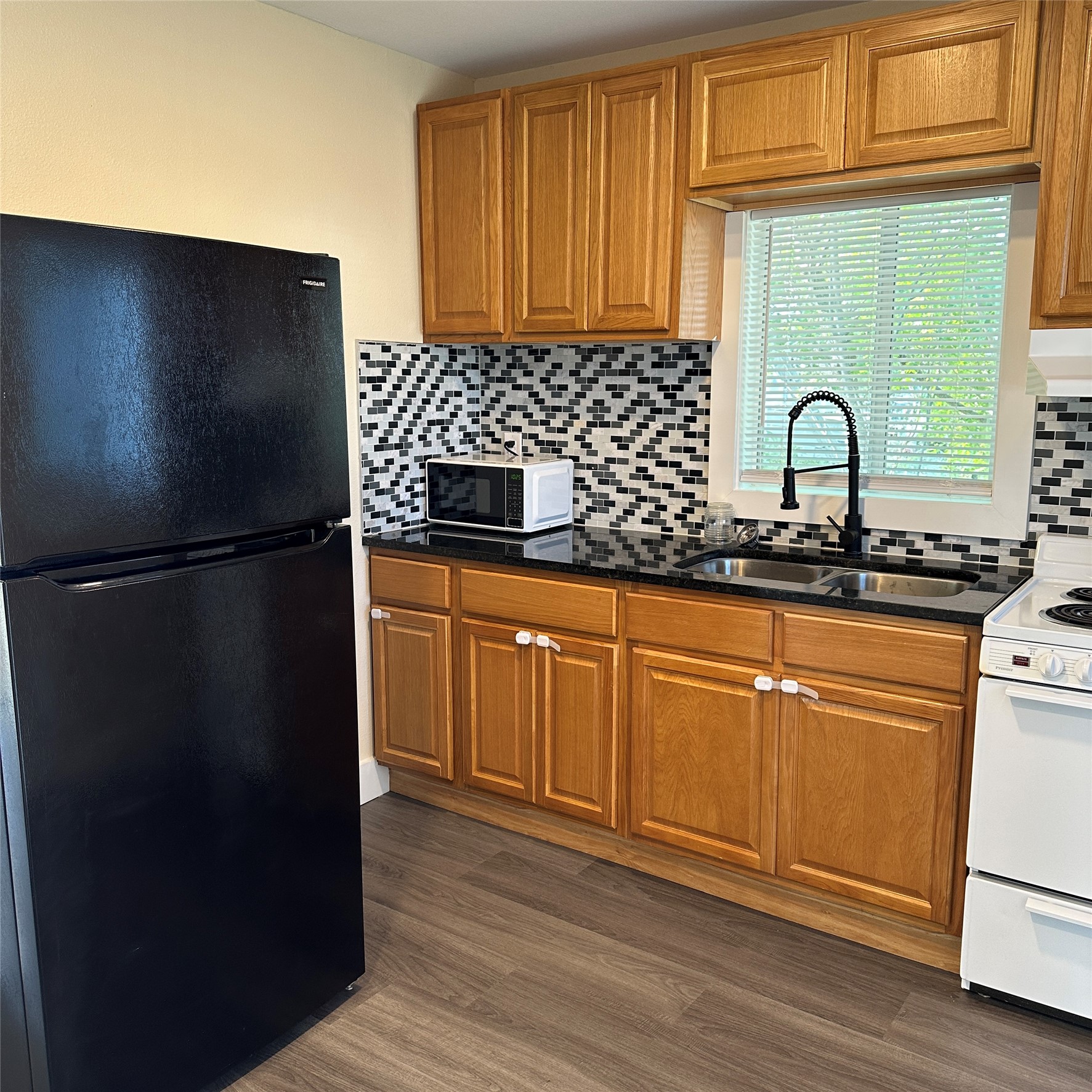 1321 Harris Hill Road San Marcos, TX 78666 - Photo 3 of 11 a kitchen with granite countertop white cabinets and black appliances