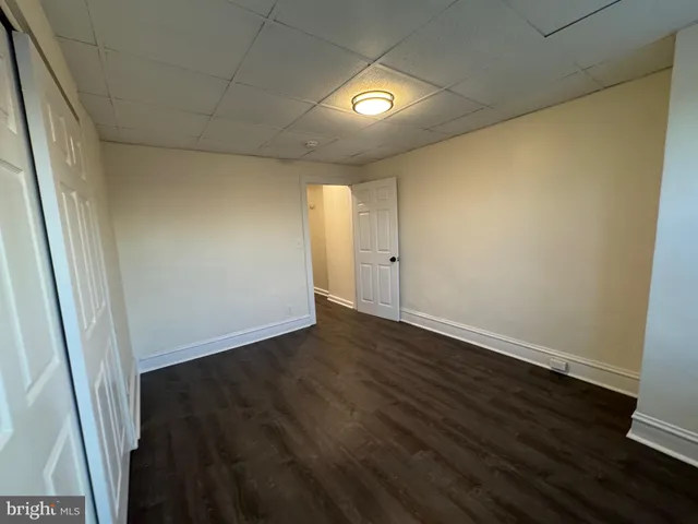 an empty room with wooden floor and window